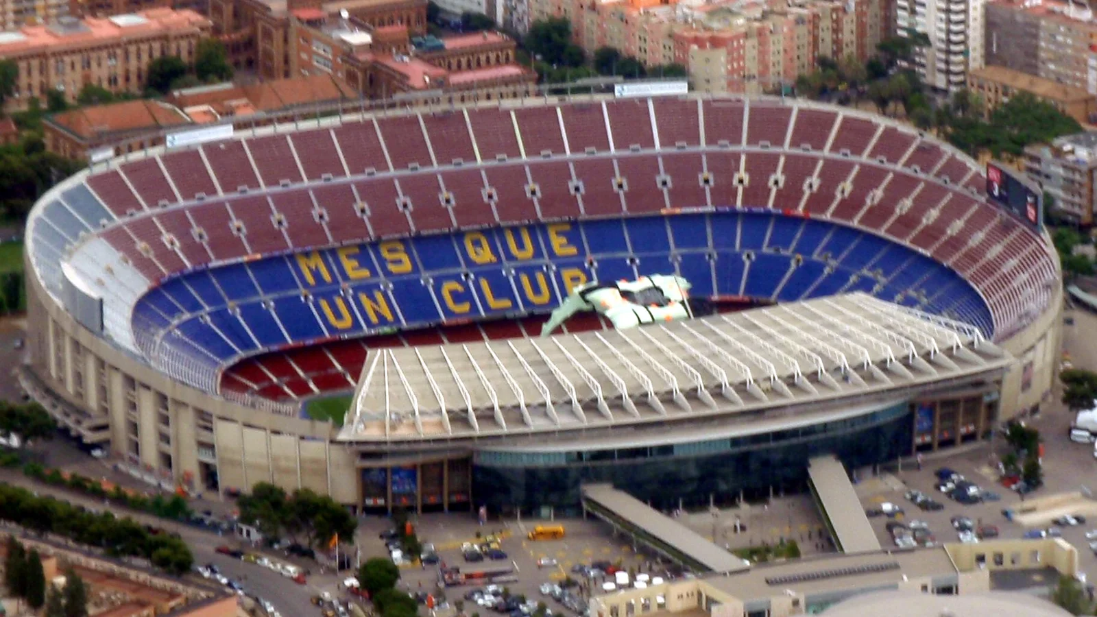 Vista aérea del Camp Nou y de sus gradas, con edificios de Barcelona al fondo.