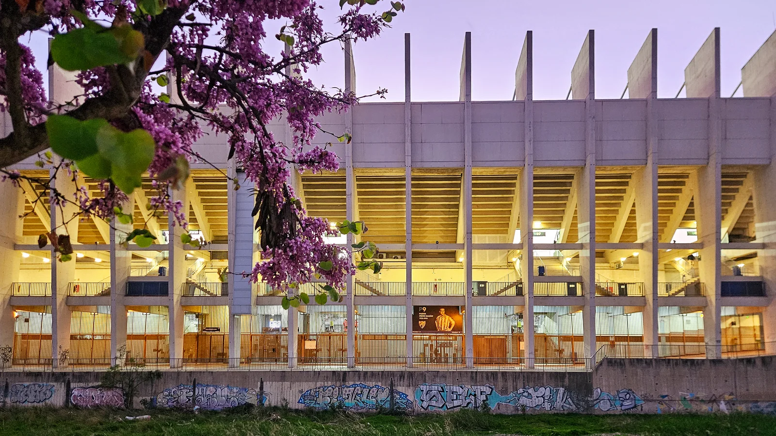 Exterior iluminado del estadio de La Rosaleda al anochecer en la ciudad de Málaga.
